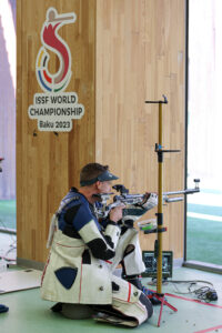 A man shooting a rifle in the kneeling position